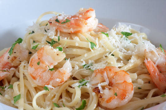 plump shrimp on a bed of pasta topped with parsley and cheese