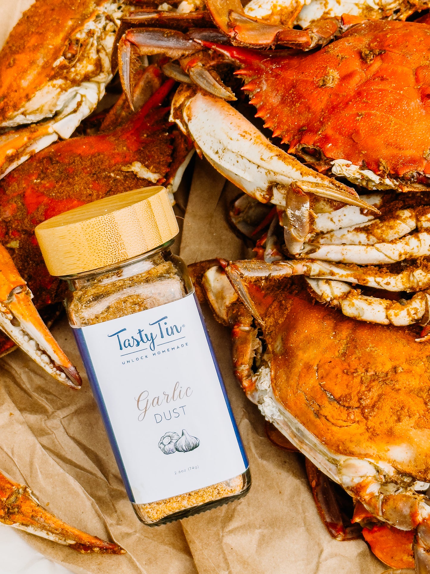 Tasty Tin garlic dust seasoning shaker placed among cooked crabs for seafood seasoning