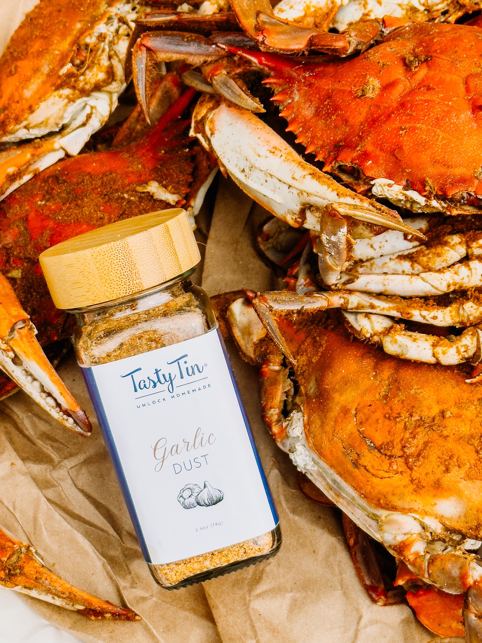 Tasty Tin garlic dust seasoning shaker placed among cooked crabs for seafood seasoning