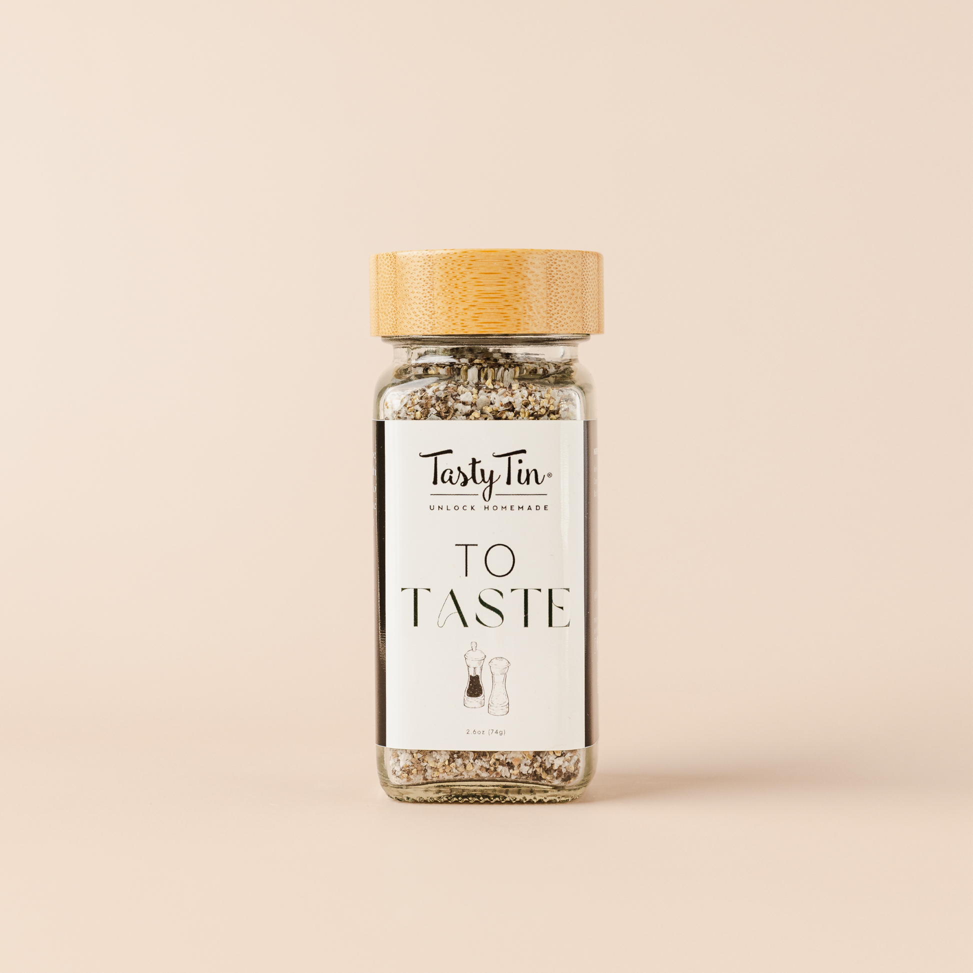 Tasty Tin gourmet seasoning shaker with bamboo lid and clear glass bottle displaying seasoning blend