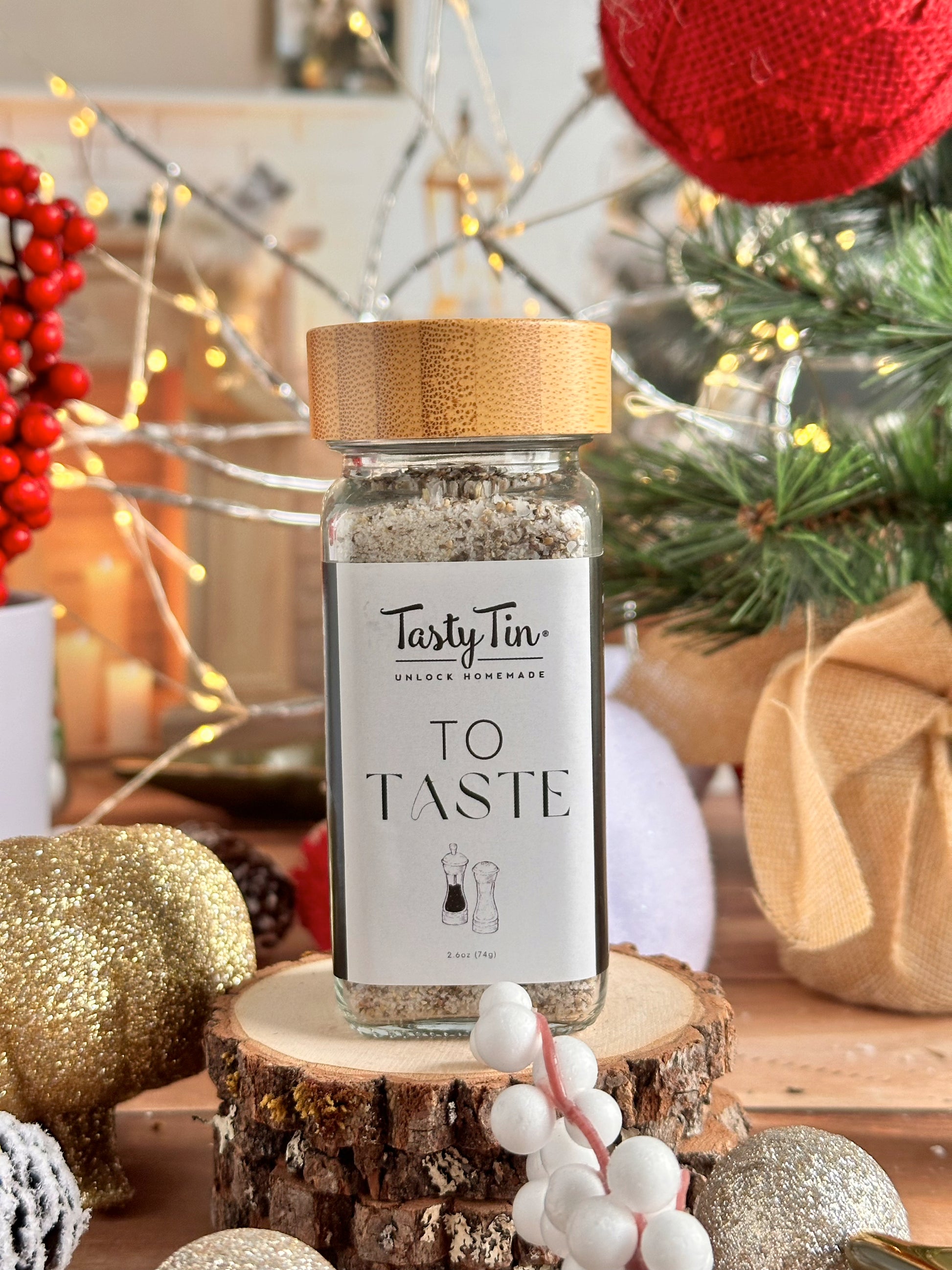 Tasty Tin gourmet seasoning shaker with bamboo lid on rustic wooden surface and festive holiday decorations