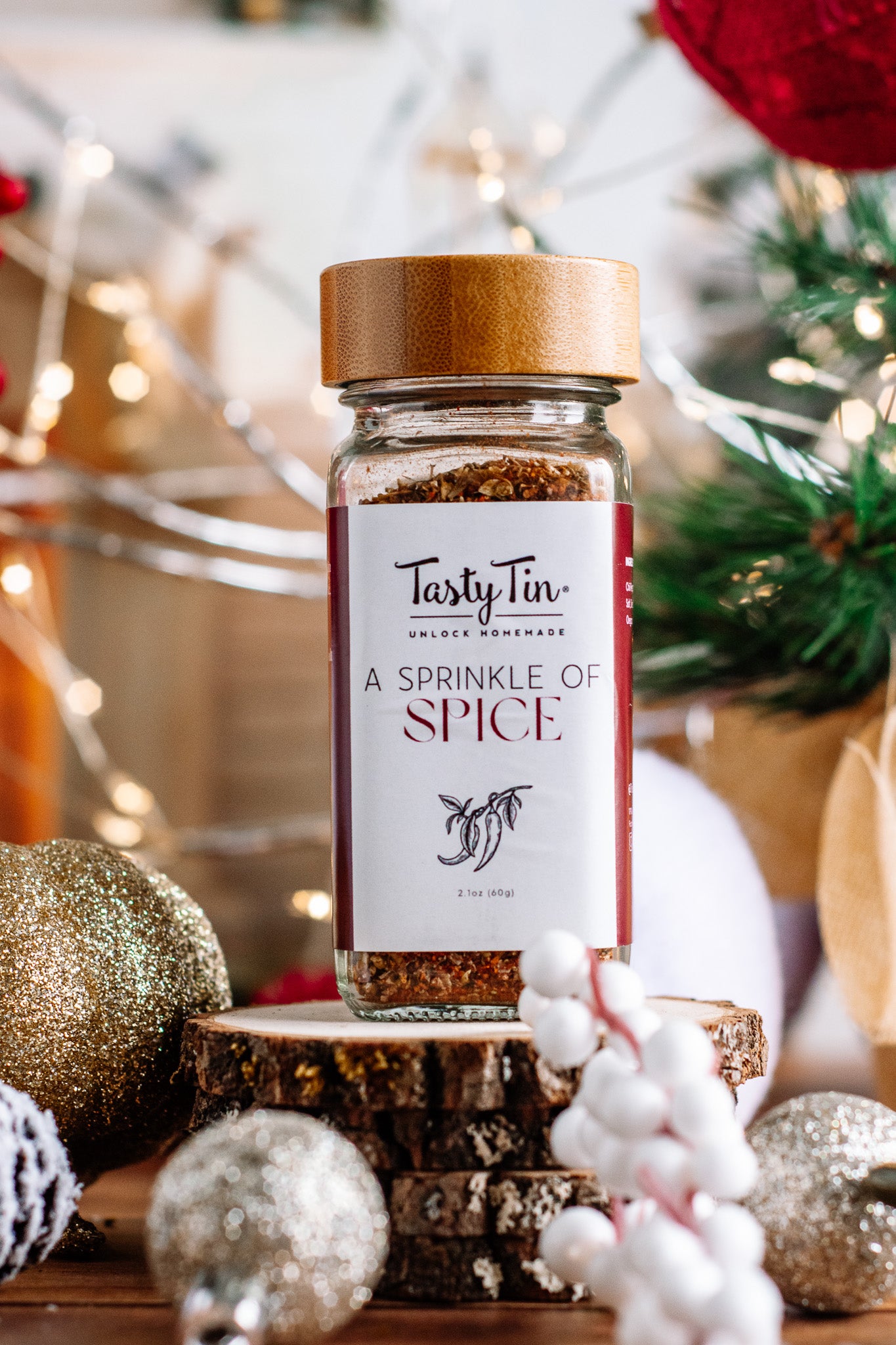 Tasty Tin gourmet spice shaker with wooden lid and A Sprinkle of Spice label on festive background