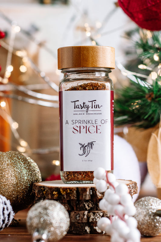 Tasty Tin gourmet spice shaker with wooden lid and A Sprinkle of Spice label on festive background