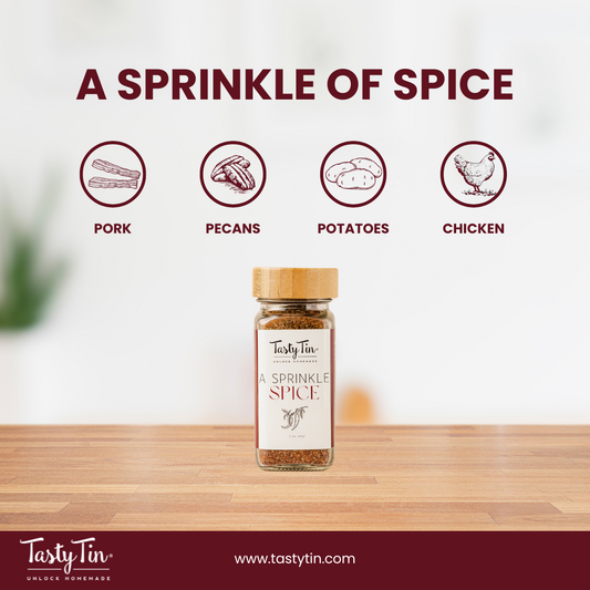 Tasty Tin gourmet spice shaker labeled A Sprinkle of Spice on wooden surface with food icons