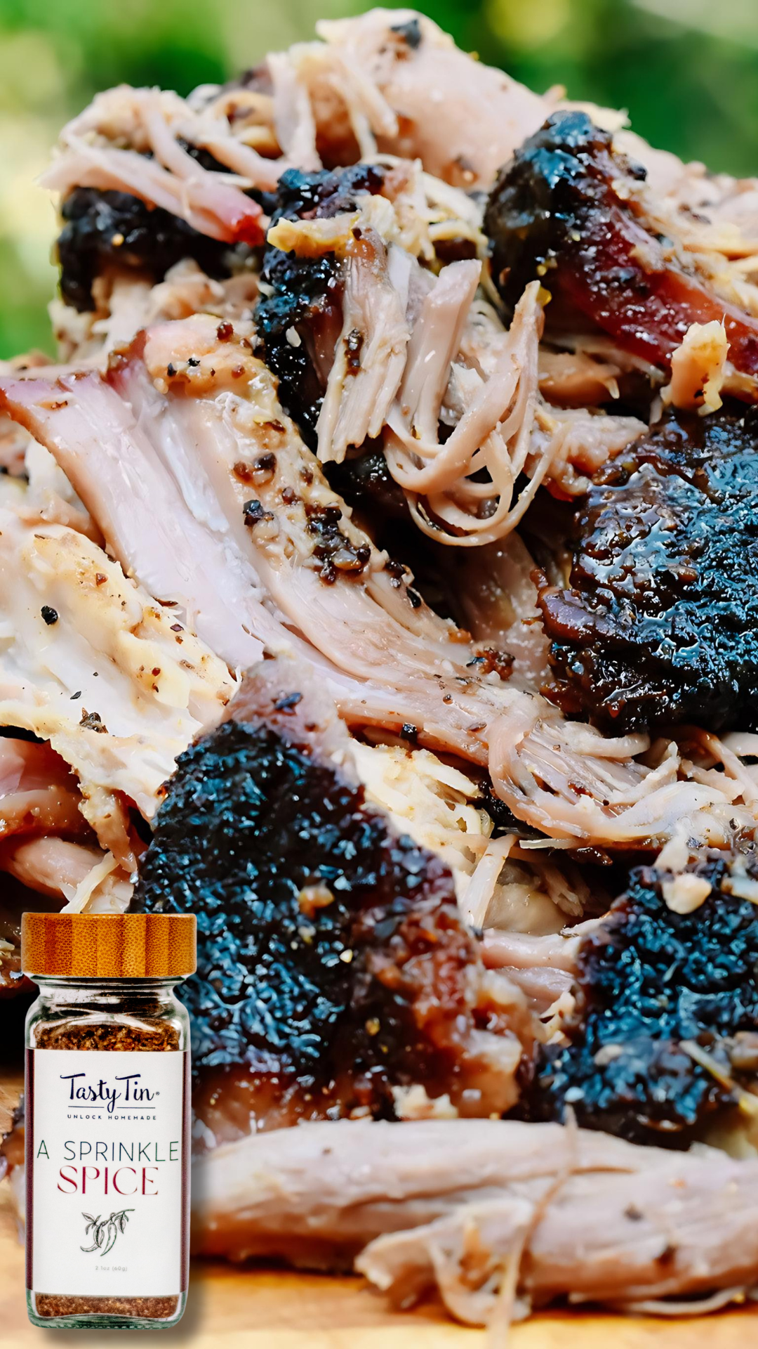 Tasty Tin gourmet spice shaker bottle next to flavorful seasoned pulled meat with crispy edges